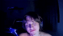 a man wearing headphones is sitting in front of a microphone with his eyes closed .