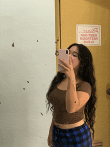 a woman taking a picture of herself in front of a door that has a sign on it
