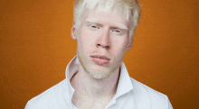 a man with white hair and a beard wearing a white shirt