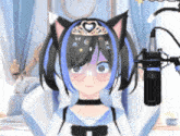 a girl with cat ears and a tiara on her head is standing in front of a microphone