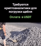 a man is digging a pile of gravel with a shovel