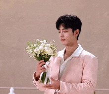 a man in a pink jacket holds a bouquet of flowers