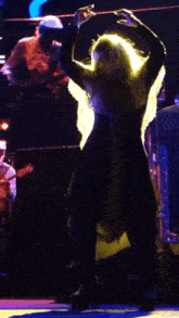 a woman in a long dress is dancing on stage