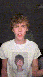 a young man wearing a white t-shirt with a picture of a man on it