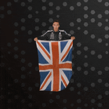 a person holding up a british flag with a black background