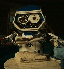 a robot is standing on a table holding a tortilla in its hands .