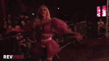 a woman in a pink dress is standing in front of a revpro logo