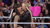 a couple kissing in a wrestling ring with a sign that says usa on it