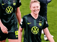 a woman wearing a black shirt with a vw logo on the front