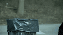 a person throwing something into a garbage can
