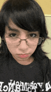 a woman wearing glasses and a black shirt that says ' hollywood '