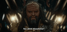 a man with long hair and a beard is asking if he drinks bloodwine