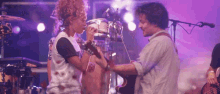 a woman singing into a microphone while a man plays guitar