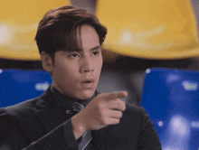 a man in a suit and tie is pointing his finger