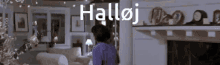 a man in a purple shirt is standing in a living room with the word halloj above him