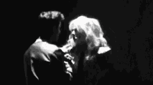 a black and white photo of a man and a woman dancing on a stage .