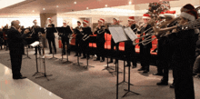 a brass band wearing santa hats is playing in a room