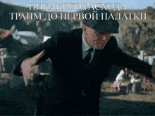 a man in a suit and tie is dancing in front of a sign that says никакого расхода