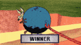 a cartoon of a coyote carrying a blue ball with a winner sign below it