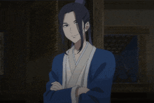 a man in a blue robe with his arms crossed looks at the camera