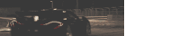 a black car with red lights is driving down a road
