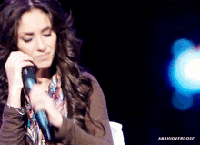 a woman singing into a microphone with the hashtag amahioverdose on the bottom