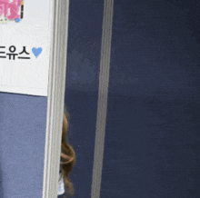 a woman peeking out from behind a cubicle with a sign that says ' a ' on it