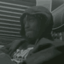 a black and white photo of a man wearing a hoodie and a sweatshirt that says ' i am ' on it