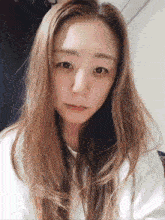 a woman with long hair looks at the camera