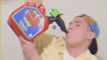 a man is drinking from a gas can with a straw .