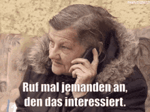 an elderly woman is talking on a cell phone and says " ruf mal jemanden an "