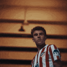 a man wearing a red and white striped shirt with the letter e on his arm