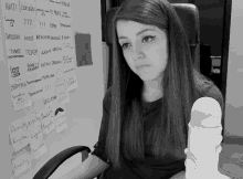 a woman is sitting in front of a white board with russian writing