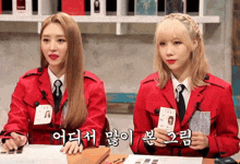 two girls wearing red jackets and ties with korean writing