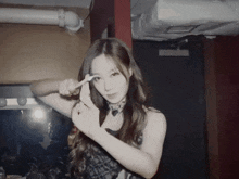 a woman in a black lace dress is making a heart with her hands