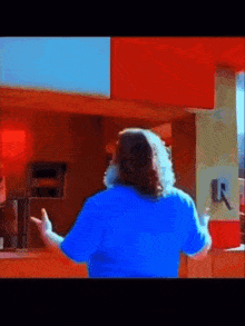a man in a blue shirt is standing in front of a counter