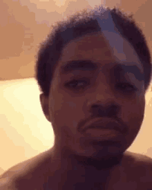 a shirtless man with a beard is making a funny face while looking at the camera .