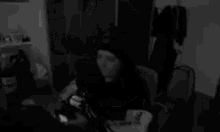 a woman is sitting in a chair in a black and white photo .