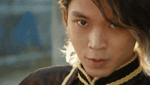 a close up of a man 's face with long hair