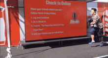 a man stands in front of a sign that says check-in online