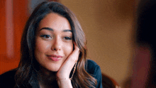 a woman with her hand on her face is smiling