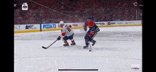 a hockey game is being played in front of a crowd with advertisements for pizza 73 and app