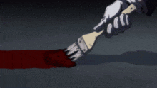 a person is holding a brush and painting a red line on the ground