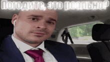 a man in a suit and tie sitting in a car