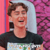 a young man wearing a black shirt that says i love you guys
