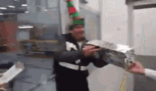 a man wearing an elf hat is holding a piece of metal in his hand .