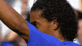 a close up of a person 's face with a blue shirt