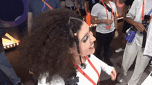 a woman wearing a lanyard that says ' a ' on it is smiling