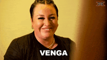 a woman is smiling with the word venga written in white
