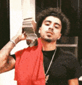a man with curly hair is holding a stack of money over his head .